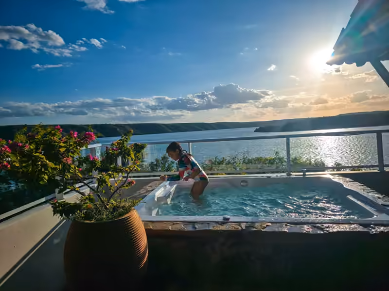 Hóspede na banheira da varanda com o sol da manhã sobre o Rio São Francisco