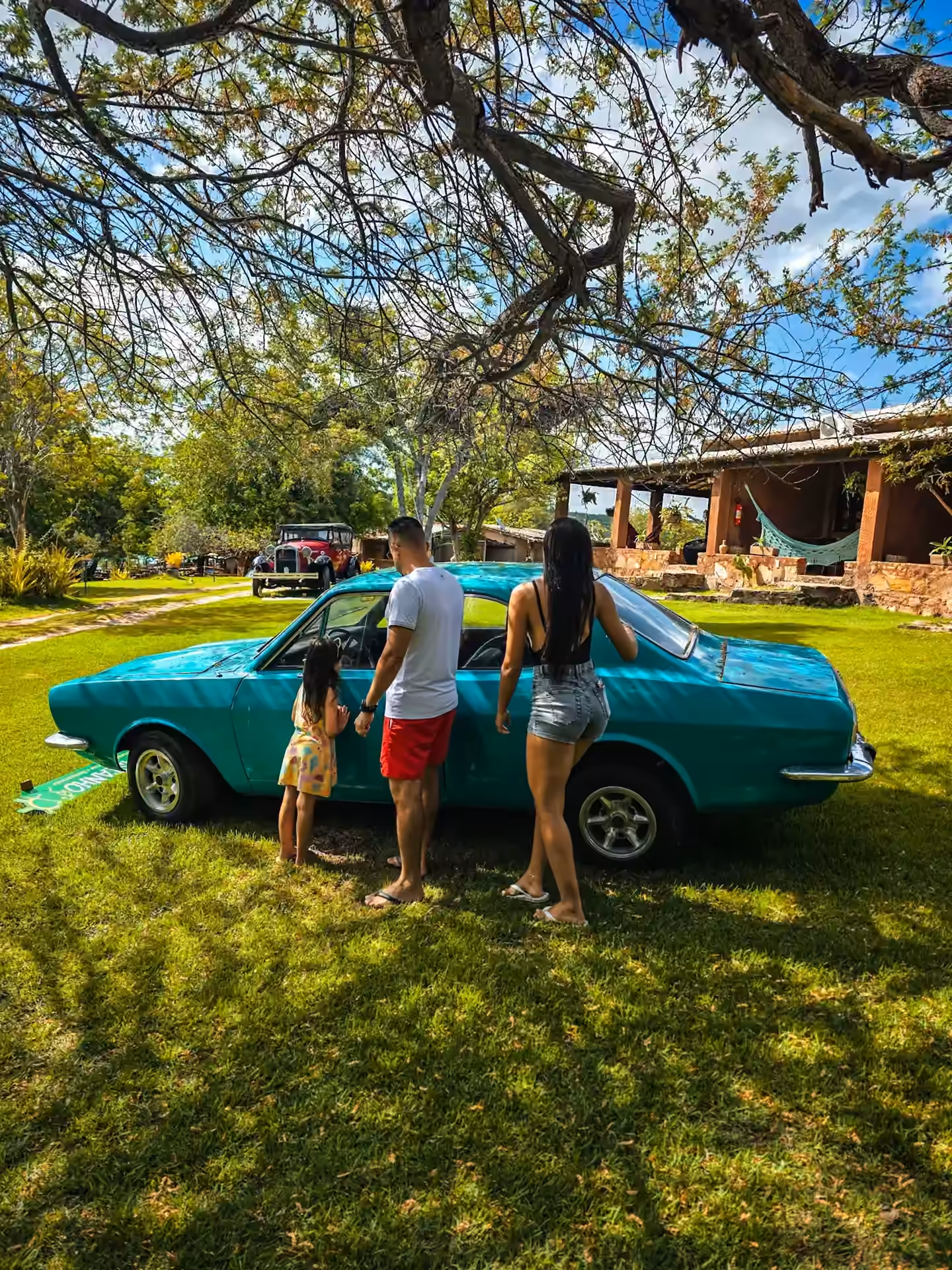 Família no gramado do Castanho ao lado de um carro antigo