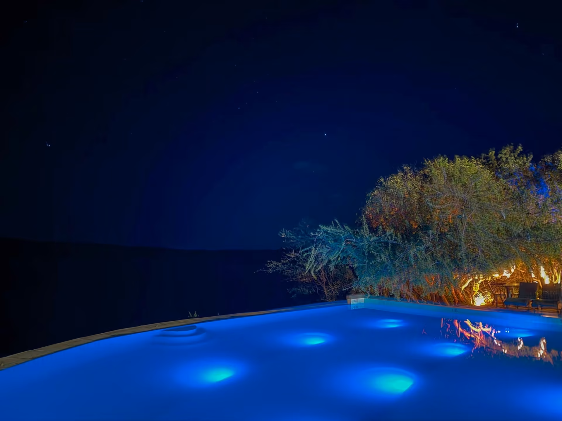 Área da piscina e do Chico Bistrô iluminada à noite
